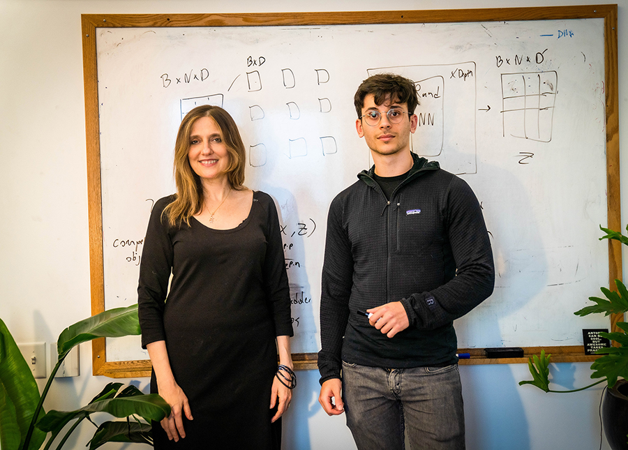 Regina Barzilay and Adam Yala stand in front of a whiteboard with scientific diagrams written on it