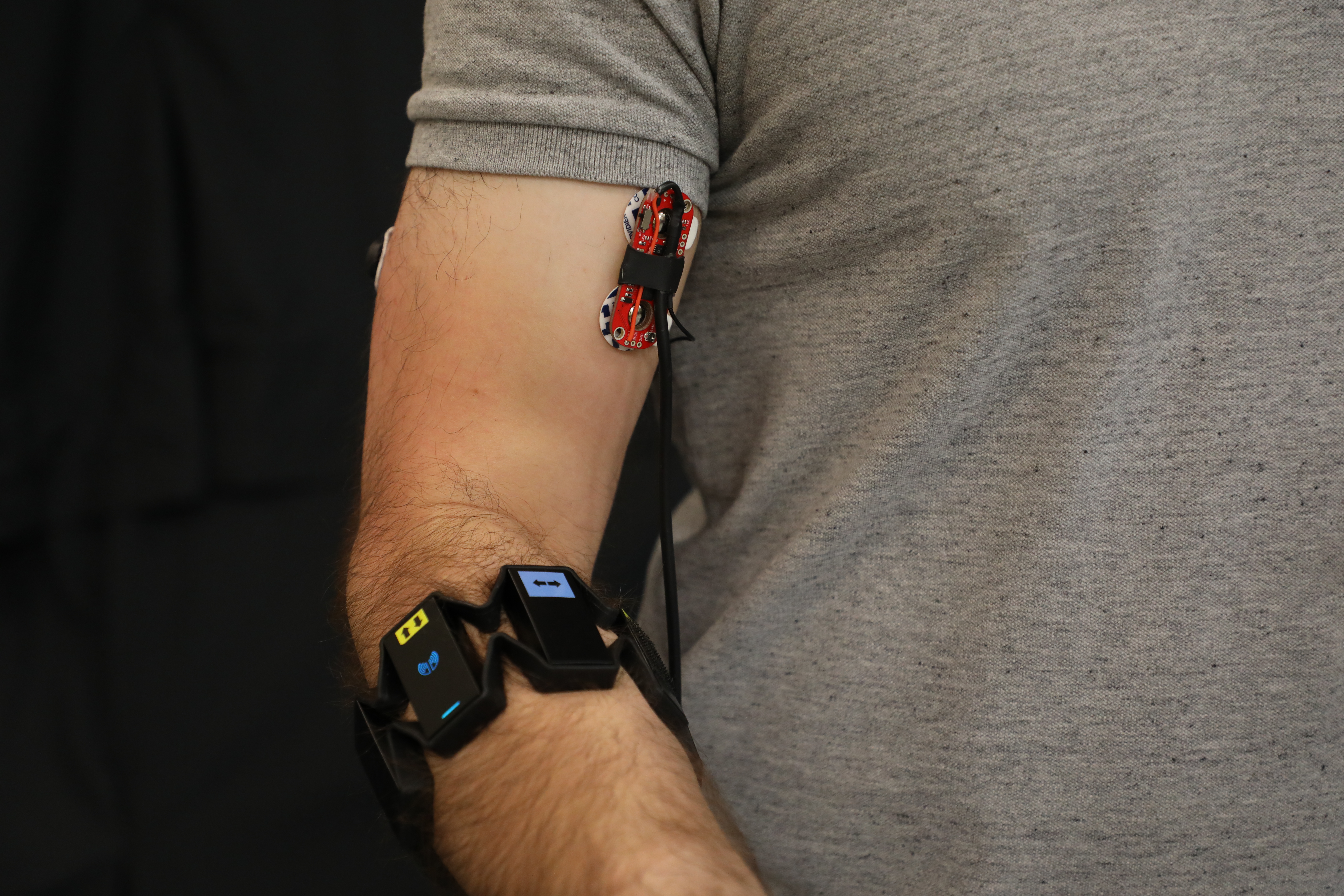 EMG sensors monitor biceps, triceps, and forearm muscles. The forearm device also includes an IMU.