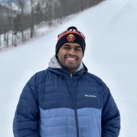 Shashata smiling with snow pit on his back.