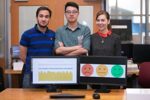 Left to right: PhD student Fadel Adib, PhD student Mingmin Zhao, and Professor Dina Katabi pose with their EQ-Radio device, which can detect emotion using wireless signals.